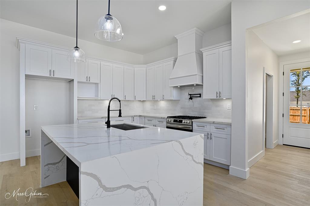 674 Rambin Road Stonewall, LA 71078 - Photo 9 of 26 a kitchen with stainless steel appliances granite countertop a sink a stove a refrigerator and island with wooden floor