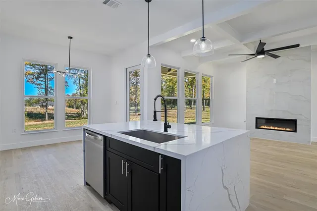 a kitchen with a sink chandelier and wooden floor