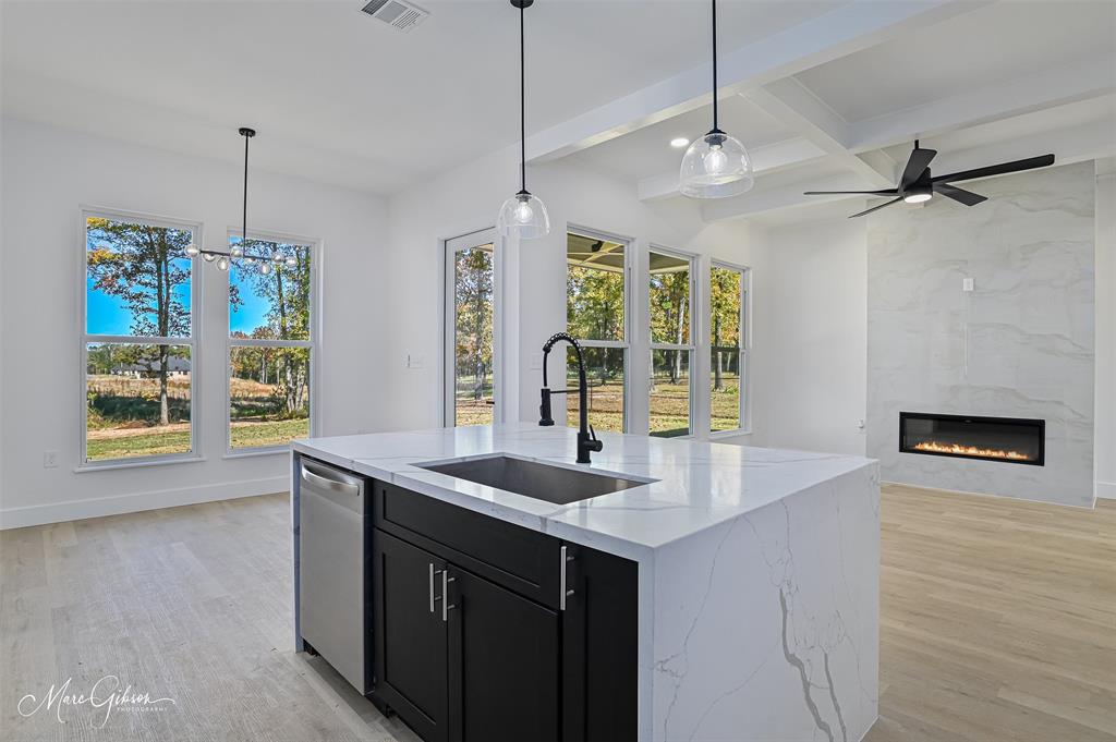 674 Rambin Road Stonewall, LA 71078 - Photo 10 of 26 a kitchen with a sink chandelier and wooden floor