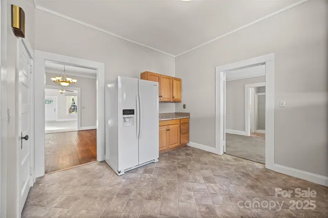 a view of a kitchen with refrigerator and more cabinets