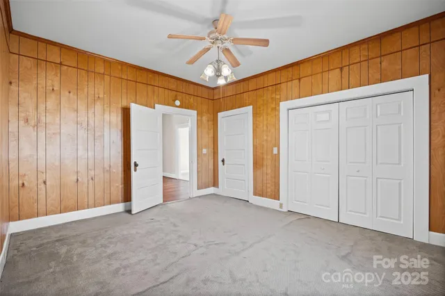 an empty room with windows and ceiling fan