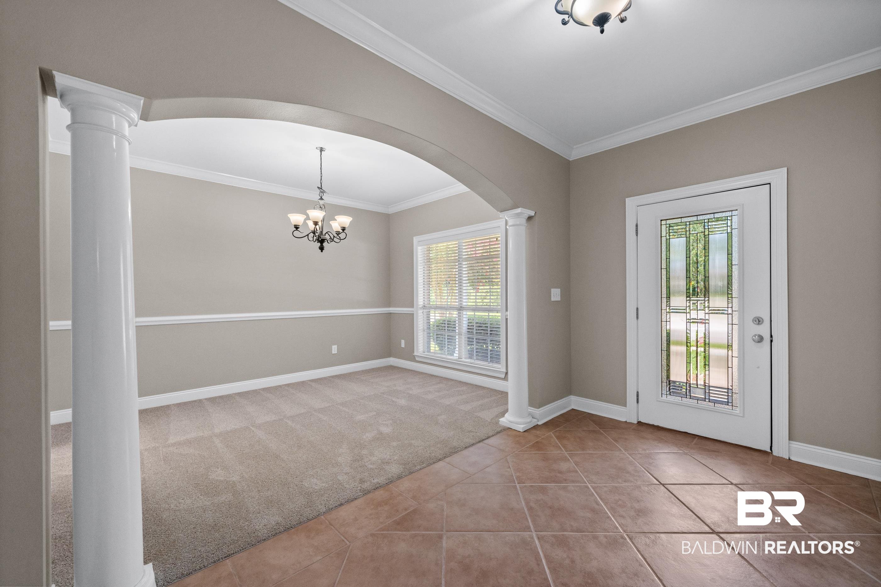 303 Savannah Circle Foley, AL 36535 - Photo 2 of 34 Foyer featuring tile flooring, an arched entryway with decorative columns, and a front door with leaded glass
