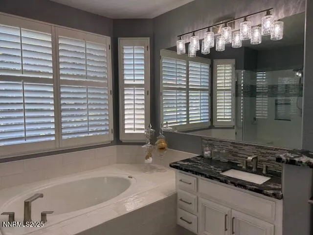 a bathroom with a granite countertop sink and a bathtub