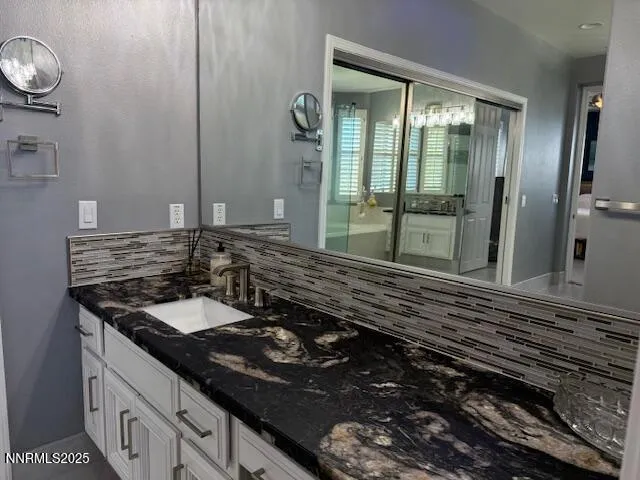 a bathroom with a granite countertop sink and a mirror