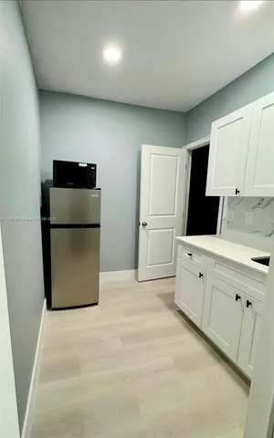 a kitchen with a refrigerator sink stove and cabinets