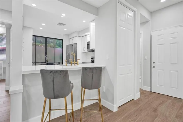 a dining hall with stainless steel appliances kitchen island granite countertop a refrigerator and a sink