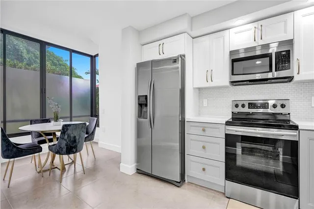 a kitchen with stainless steel appliances a stove a refrigerator and a microwave