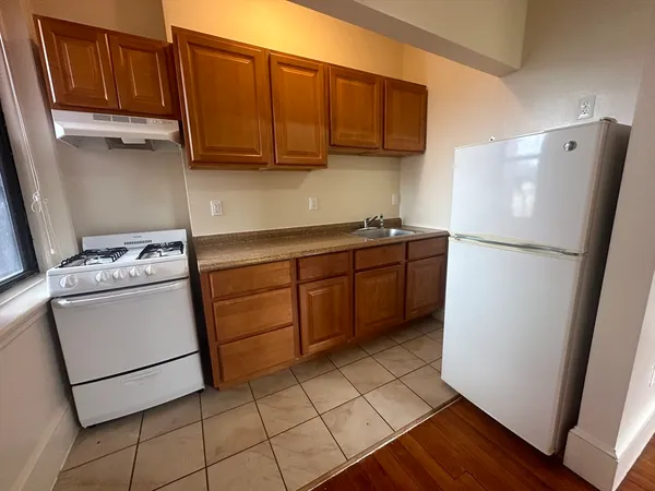 a kitchen with a refrigerator sink stove and cabinets