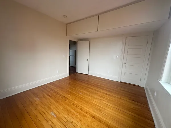 a view of empty room with wooden floor