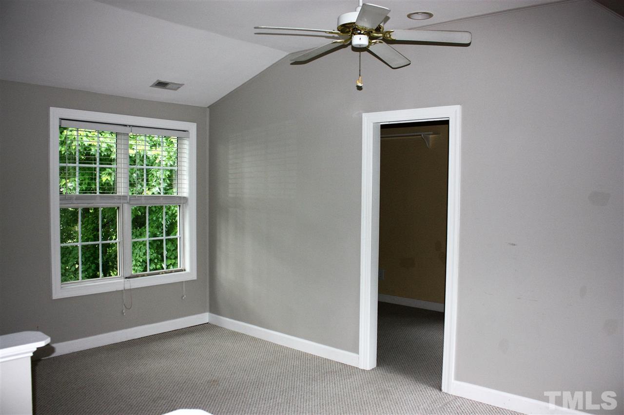 908 Cedar Downs Drive Raleigh, NC 27607 - Photo 11 of 25 an empty room with a window and a ceiling fan