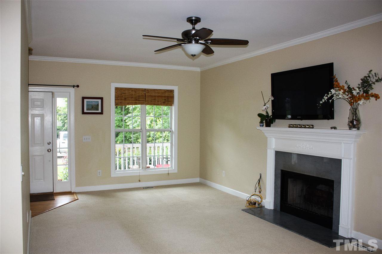 908 Cedar Downs Drive Raleigh, NC 27607 - Photo 6 of 25 a living room with a fireplace and a flat screen tv