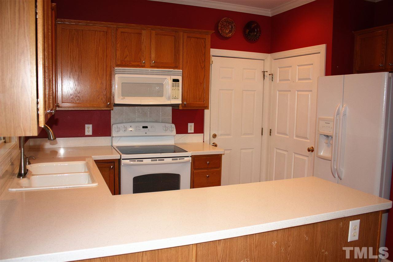 908 Cedar Downs Drive Raleigh, NC 27607 - Photo 9 of 25 a kitchen with granite countertop a refrigerator stove and sink