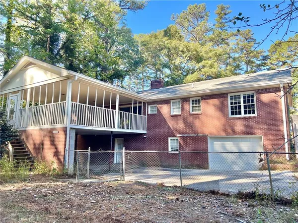 a view of a house with a yard and wooden fence