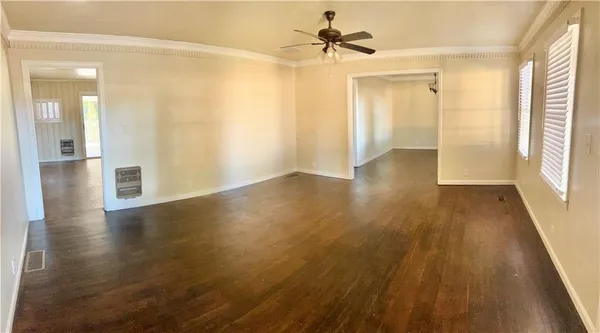 a view of a hallway with wooden floor and a bathroom