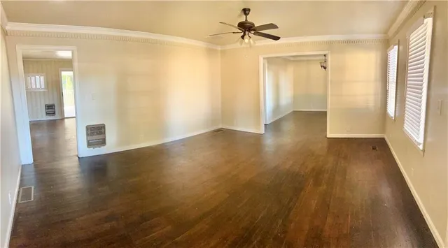 a view of a hallway with wooden floor and a bathroom