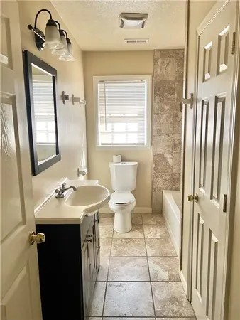 a bathroom with a sink toilet and mirror