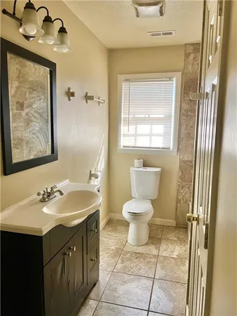 a bathroom with a sink a toilet and mirror