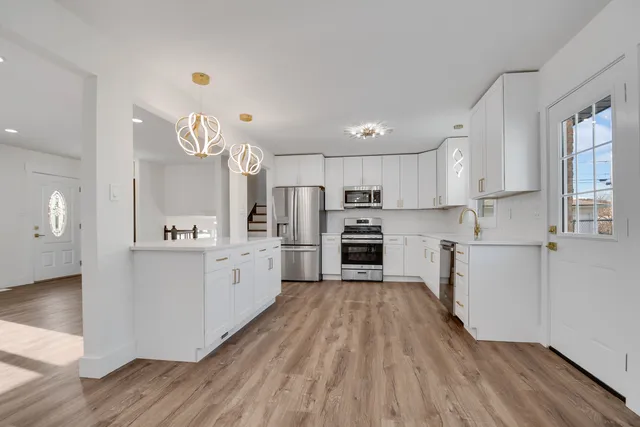 a kitchen with white cabinets and stainless steel appliances