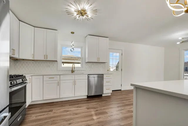 a kitchen with granite countertop white cabinets and stainless steel appliances