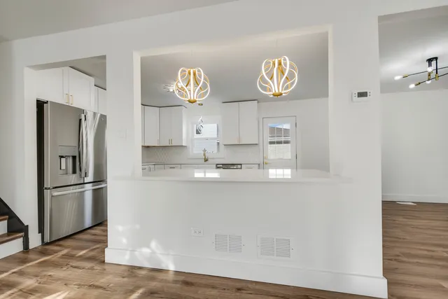 a kitchen with stainless steel appliances granite countertop a refrigerator a stove and a sink