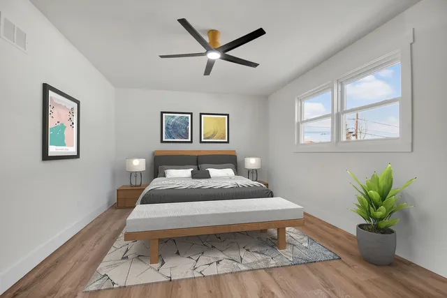 a bedroom with a large bed and a potted plant