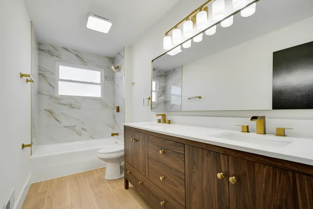 a bathroom with a sink a toilet and shower