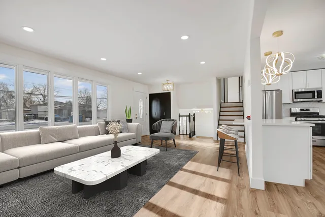 a living room with furniture wooden floor and a large window