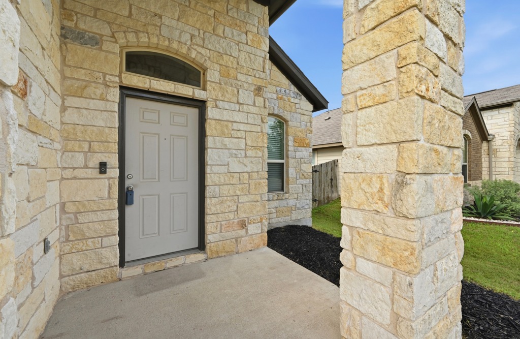 Textured stone masonry frames the welcoming covered entry of this modern residence.