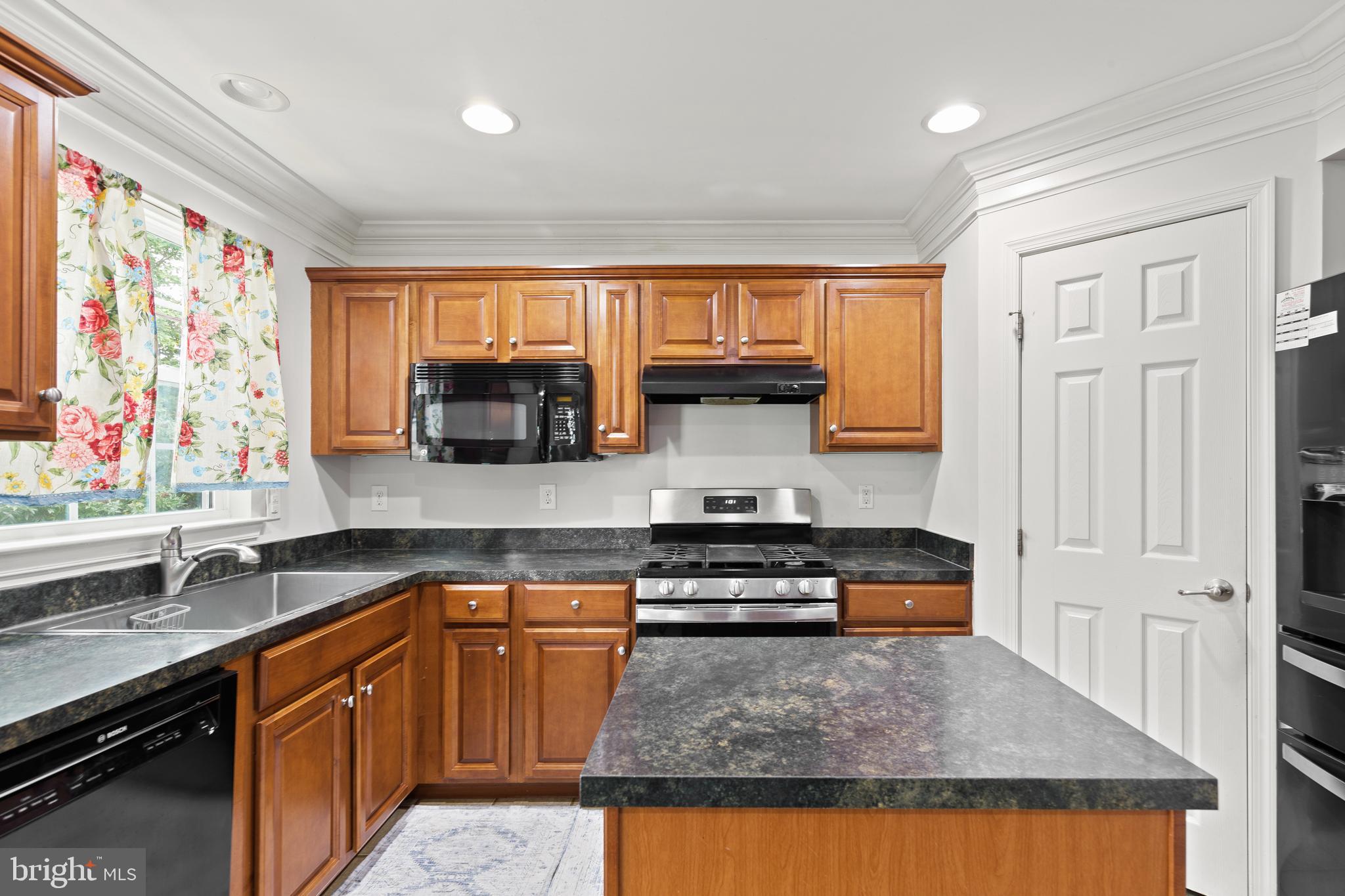 196 Bobbys Branch Road Millsboro, DE 19966 - Photo 13 of 37 a kitchen with stainless steel appliances granite countertop a stove a sink and a microwave