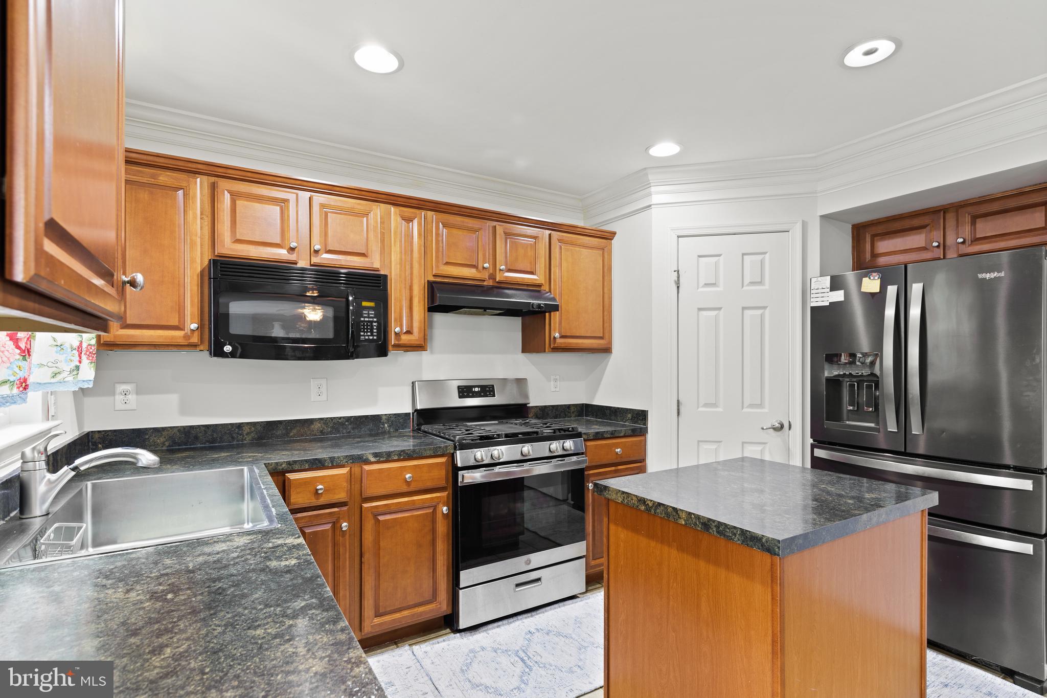 196 Bobbys Branch Road Millsboro, DE 19966 - Photo 14 of 37 a kitchen with granite countertop a sink stove and refrigerator