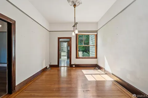 wooden floor in an empty room with a window