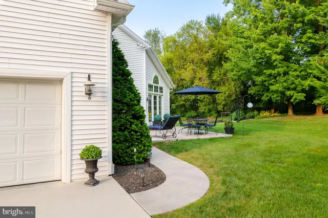 a view of a chair and table in backyard of the house