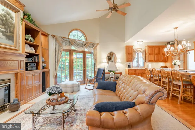 a living room with furniture a fireplace and a chandelier