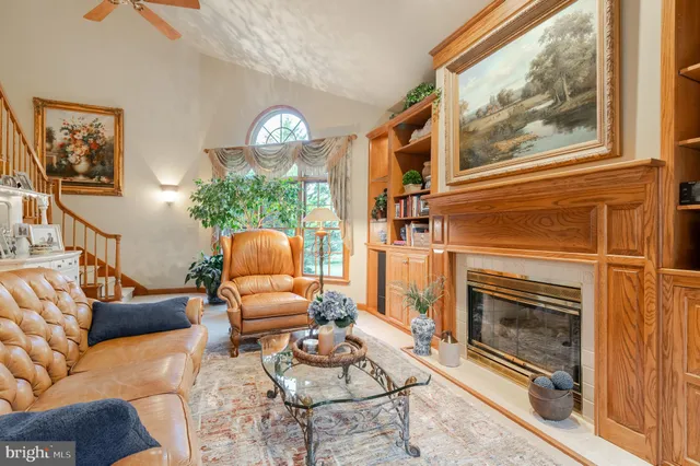 a living room with furniture a fireplace and a floor to ceiling window