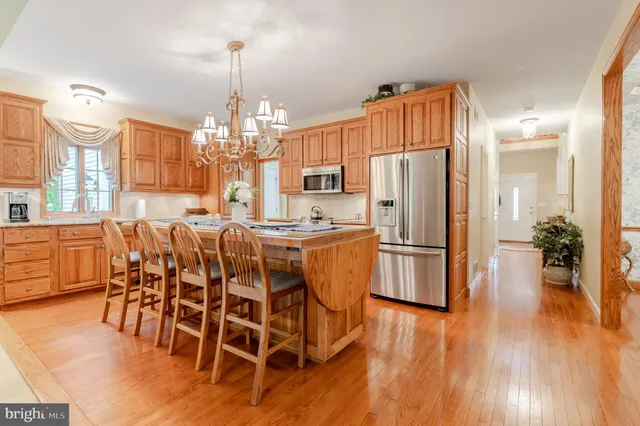 a kitchen with stainless steel appliances a dining table chairs and chandelier