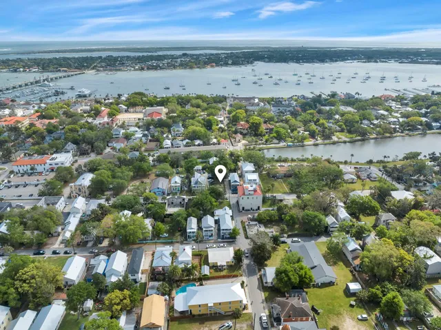 an aerial view of ocean and residential houses with outdoor space