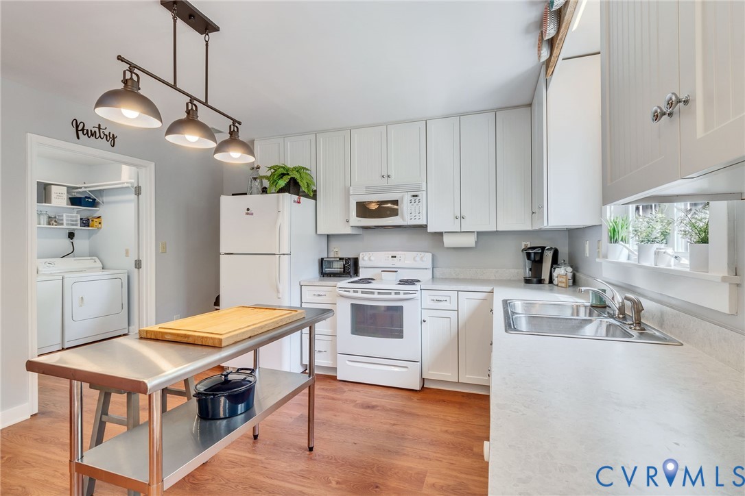 193 Deep Water Lane Reedville, VA 22539 - Photo 9 of 84 a kitchen with stainless steel appliances granite countertop a stove a refrigerator a sink dishwasher and a dining table with wooden floor
