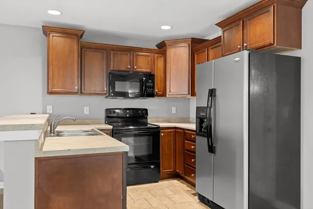 a kitchen with stainless steel appliances granite countertop a refrigerator stove microwave and sink