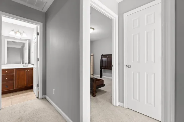 a view of a hallway with a livingroom and a bathroom