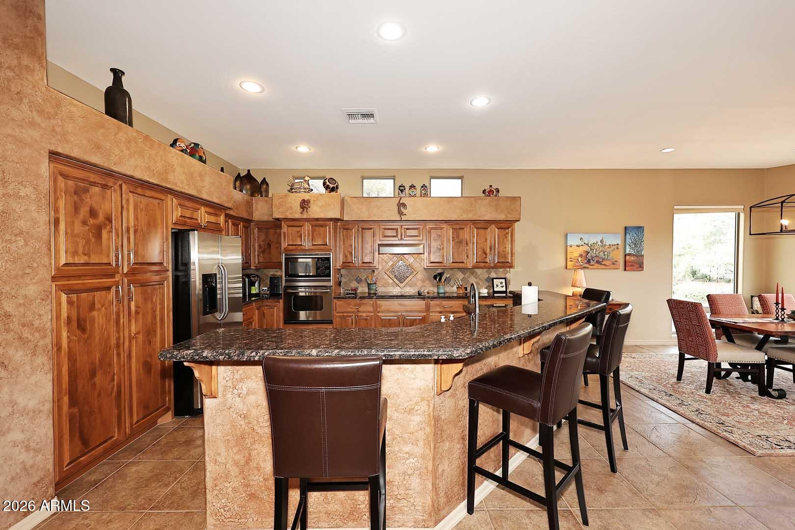 27921 North Quail Spring Road Rio Verde, AZ 85263 - Photo 11 of 49 a kitchen with stainless steel appliances granite countertop table chairs sink and cabinets