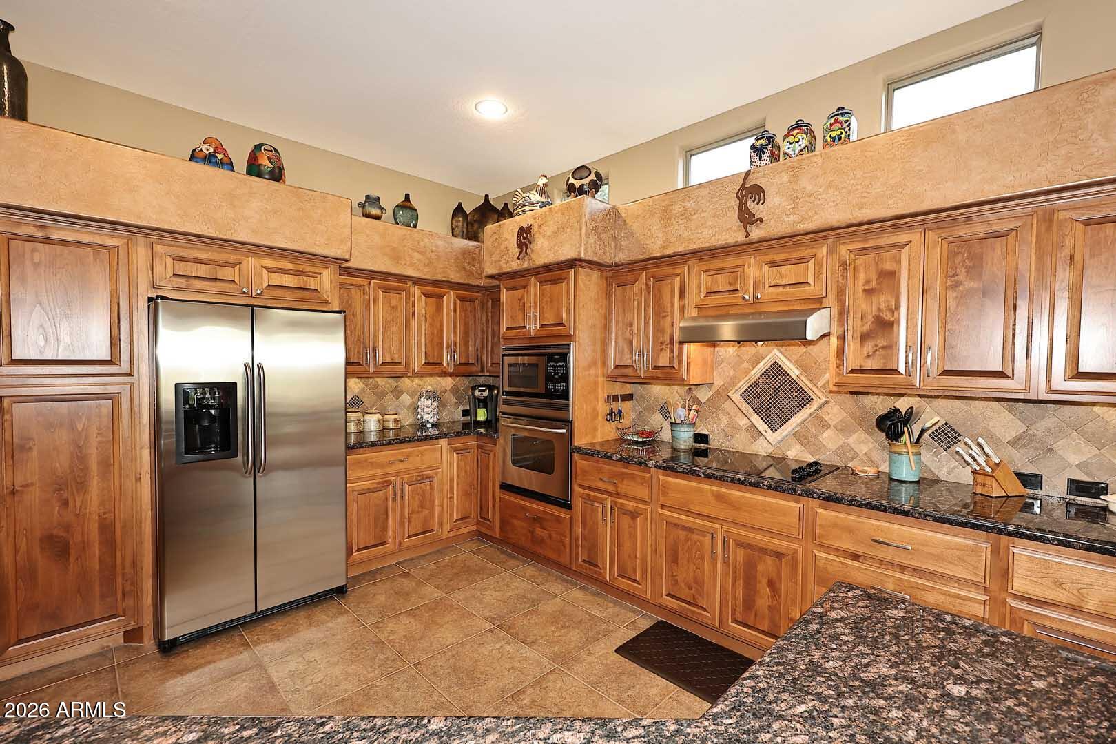 27921 North Quail Spring Road Rio Verde, AZ 85263 - Photo 13 of 49 a kitchen with stainless steel appliances granite countertop a refrigerator and stove
