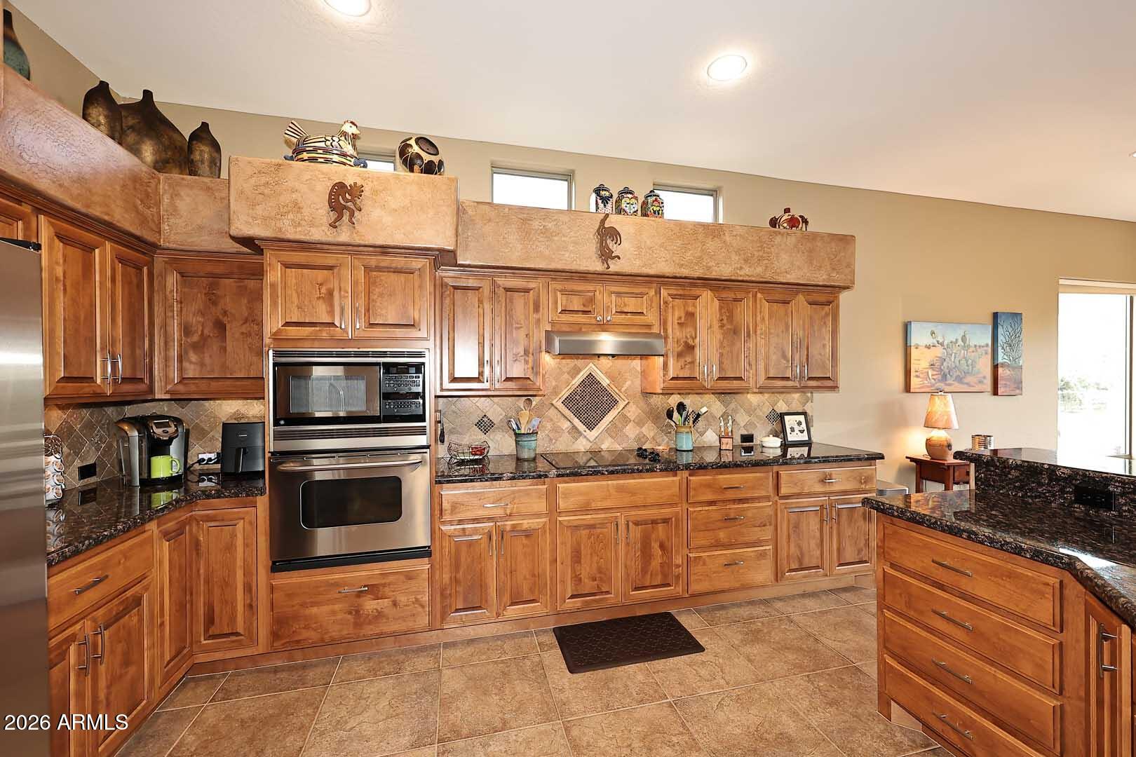27921 North Quail Spring Road Rio Verde, AZ 85263 - Photo 14 of 49 a kitchen with stainless steel appliances kitchen island granite countertop a sink and cabinets