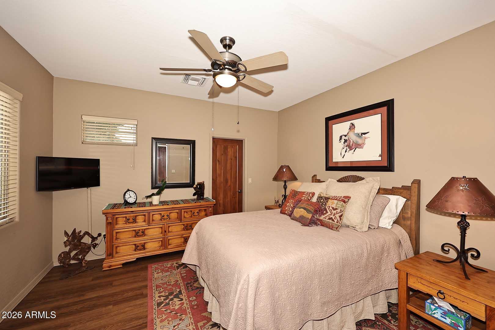 27921 North Quail Spring Road Rio Verde, AZ 85263 - Photo 18 of 49 a bedroom with a bed and wooden floor