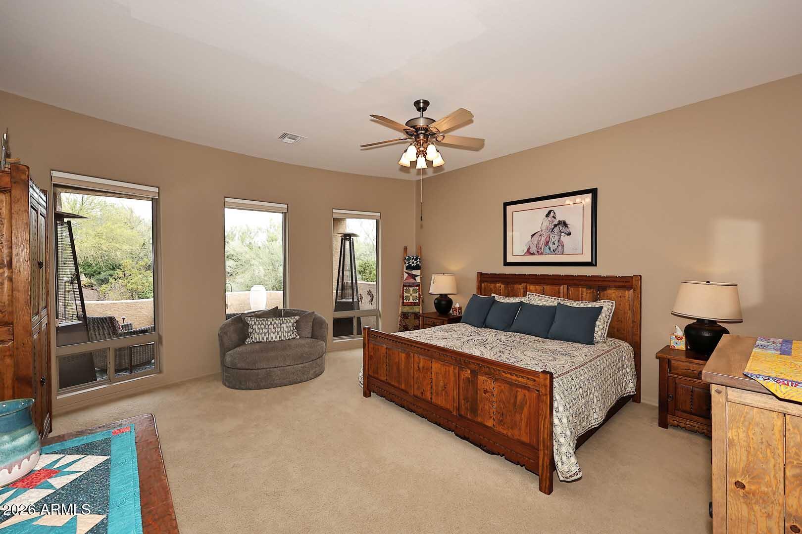 27921 North Quail Spring Road Rio Verde, AZ 85263 - Photo 20 of 49 a spacious bedroom with a bed and a chandelier