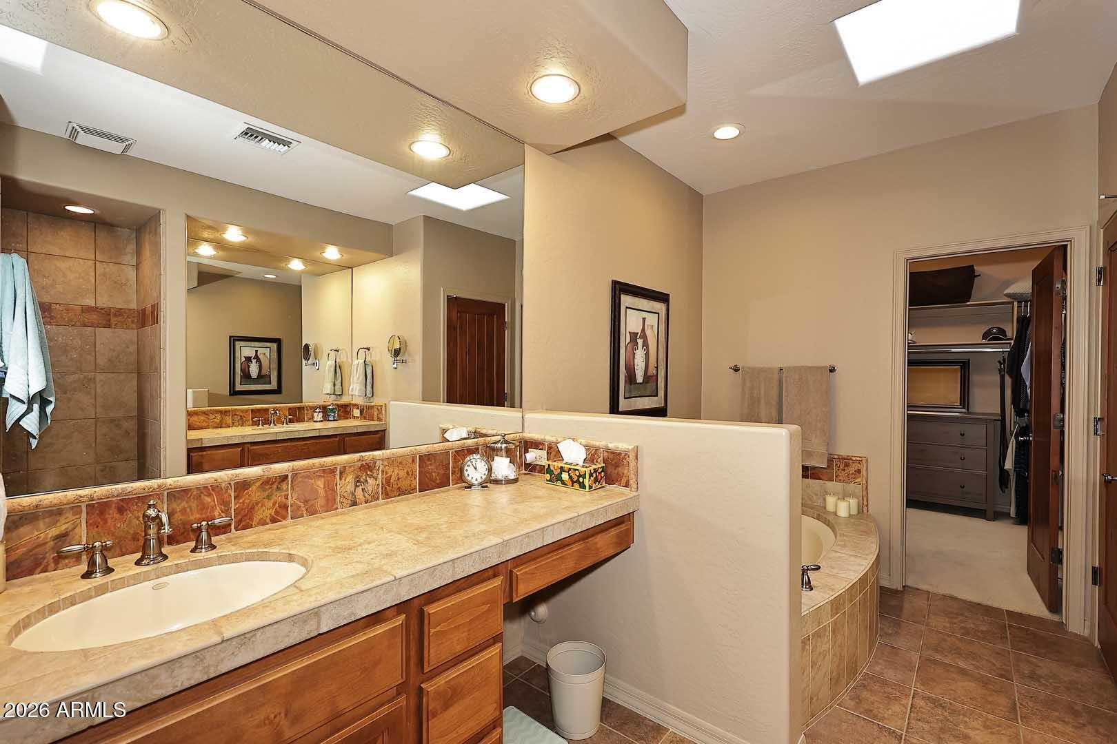 27921 North Quail Spring Road Rio Verde, AZ 85263 - Photo 23 of 49 a bathroom with a granite countertop sink a large mirror and a shower