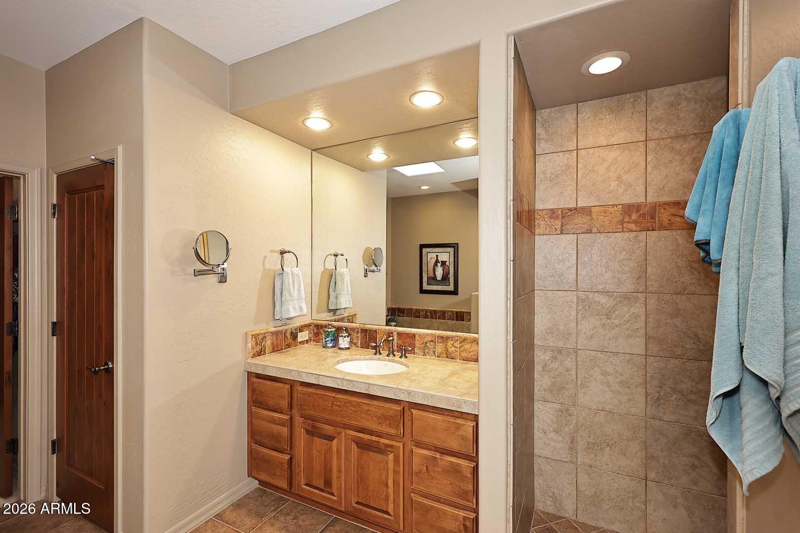 27921 North Quail Spring Road Rio Verde, AZ 85263 - Photo 24 of 49 a bathroom with a double vanity sink a mirror and shower