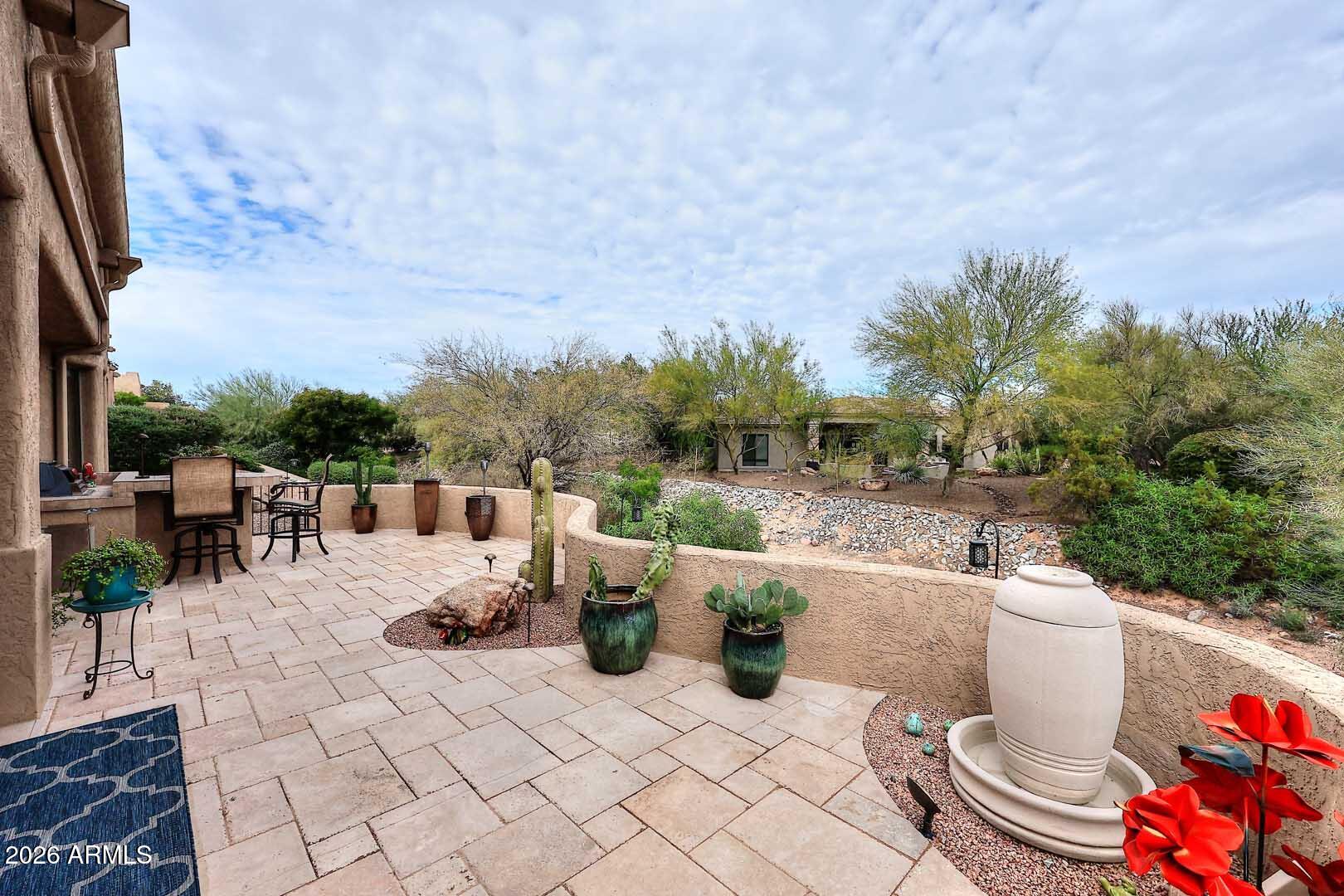 27921 North Quail Spring Road Rio Verde, AZ 85263 - Photo 35 of 49 a view of a patio with a dining table and chairs with wooden fence