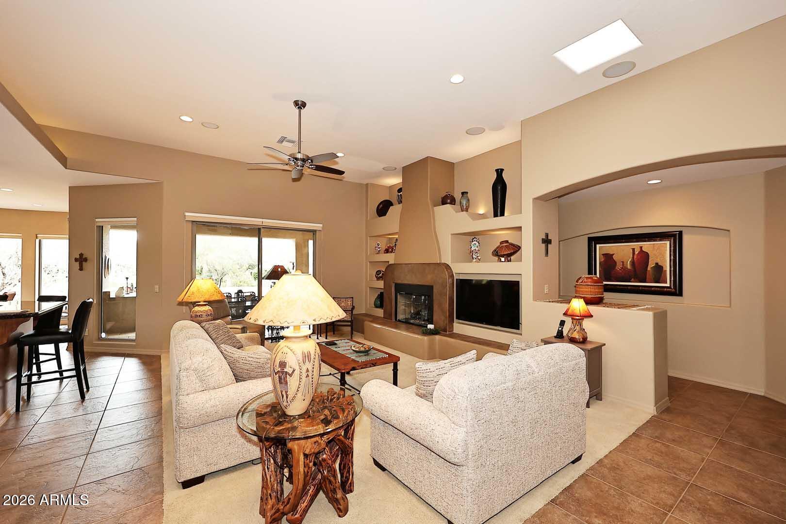27921 North Quail Spring Road Rio Verde, AZ 85263 - Photo 5 of 49 a living room with furniture a fireplace and a flat screen tv