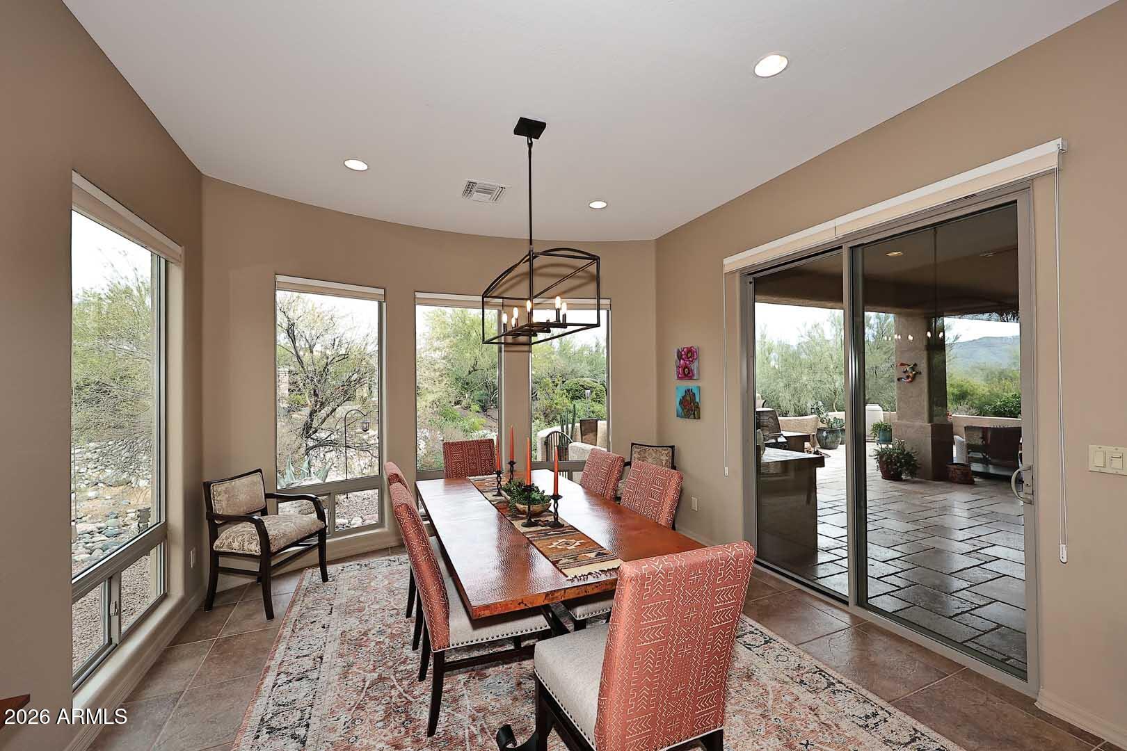 27921 North Quail Spring Road Rio Verde, AZ 85263 - Photo 10 of 49 a dining room with furniture large windows and a chandelier