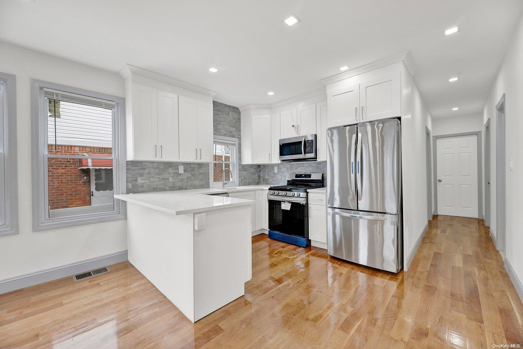 a kitchen with granite countertop appliances a sink and a refrigerator